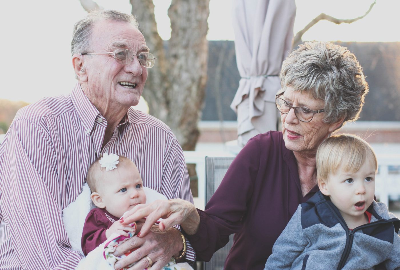 Grandparents sitting outdoors with their grandchildren